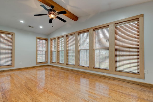 unfurnished room featuring a wealth of natural light, light hardwood / wood-style flooring, and lofted ceiling with beams