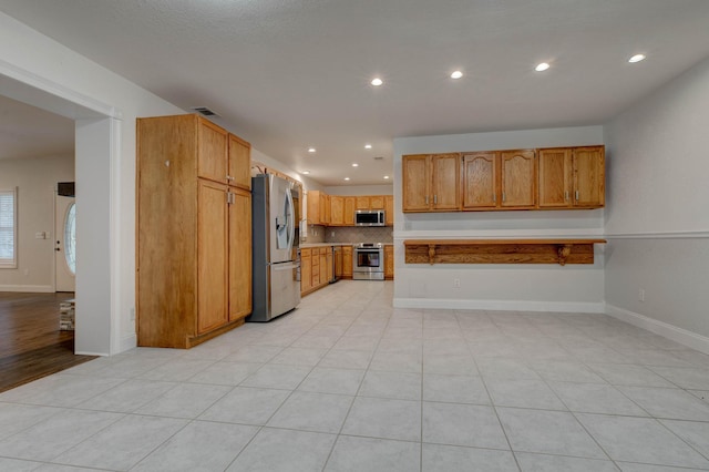 kitchen featuring light tile patterned floors, backsplash, and stainless steel appliances