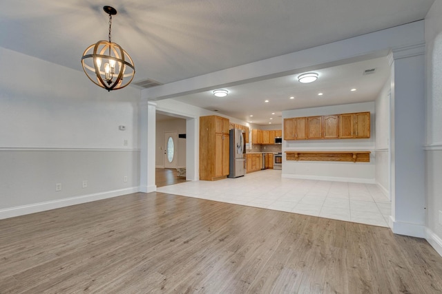 unfurnished living room featuring light hardwood / wood-style floors and a chandelier