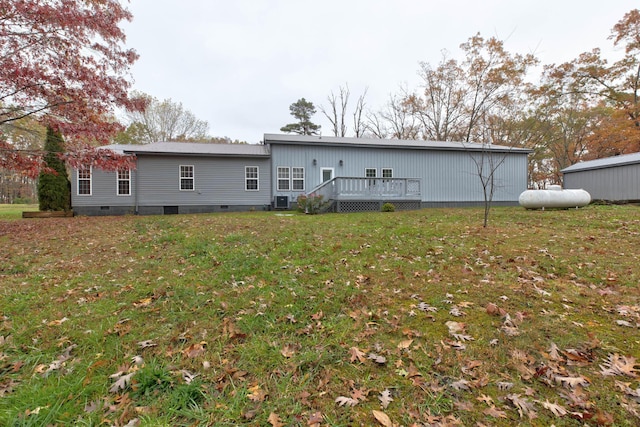 rear view of house with central air condition unit, a wooden deck, and a yard