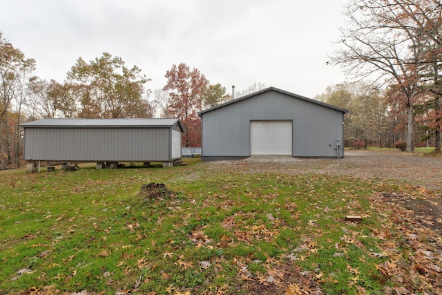 exterior space featuring a lawn, a garage, and an outdoor structure