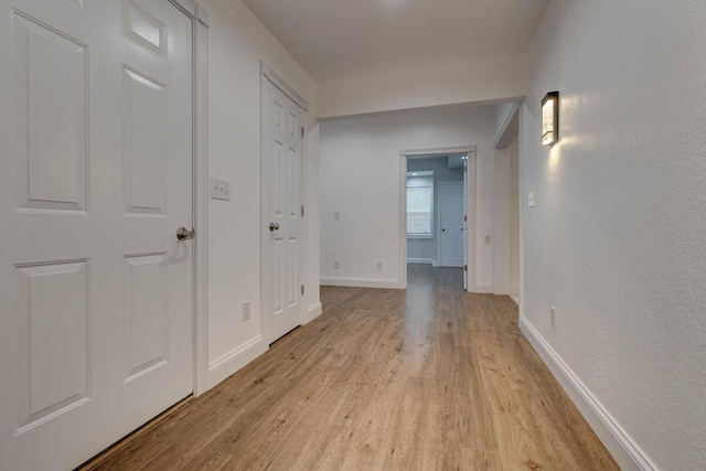 corridor with light hardwood / wood-style floors