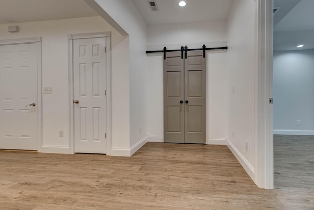 interior space featuring a barn door and light wood-type flooring