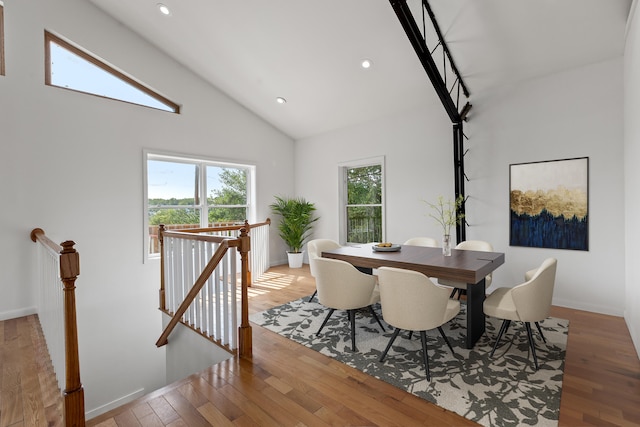 dining area with high vaulted ceiling and light wood-type flooring