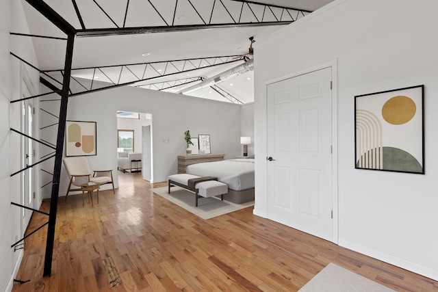 bedroom with hardwood / wood-style flooring and lofted ceiling