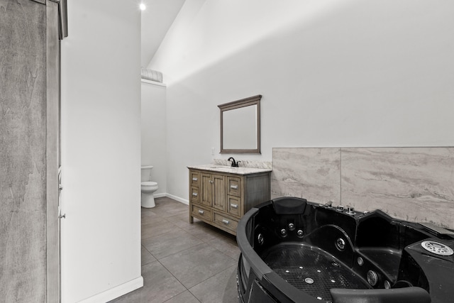 bathroom featuring a washtub, tile patterned flooring, vanity, and toilet