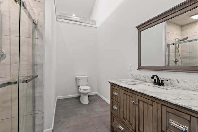 bathroom featuring tile patterned floors, vanity, a shower with shower door, and toilet