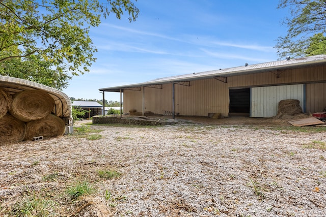 view of side of home featuring an outbuilding