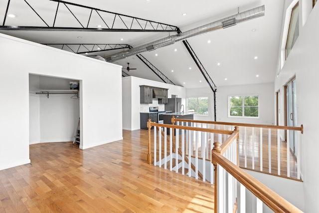 hall featuring beam ceiling, sink, high vaulted ceiling, and light hardwood / wood-style floors