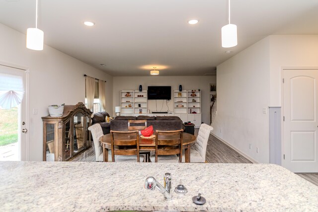 kitchen with light hardwood / wood-style flooring, tasteful backsplash, light stone counters, and stainless steel appliances