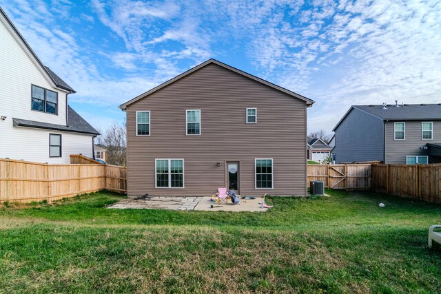 back of property featuring central AC unit, a patio area, and a yard