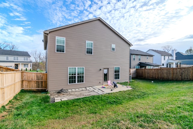 back of house with a lawn and a patio area