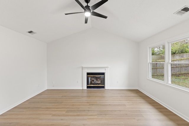 unfurnished living room with ceiling fan, a tiled fireplace, light hardwood / wood-style flooring, and lofted ceiling