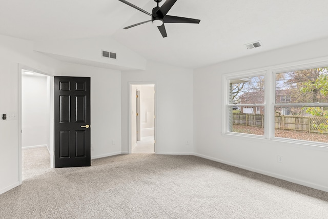 carpeted spare room with ceiling fan and vaulted ceiling