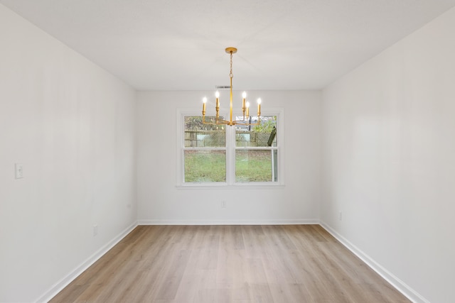 unfurnished room with light hardwood / wood-style floors and a notable chandelier