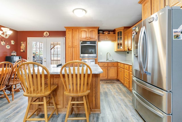 kitchen featuring light hardwood / wood-style flooring, sink, a kitchen bar, and stainless steel appliances