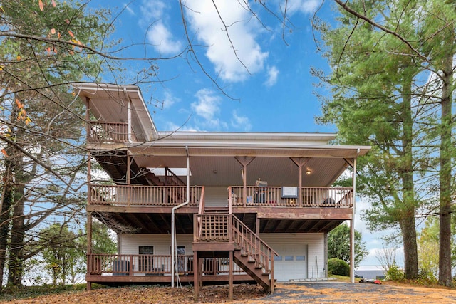 back of house with a garage and a wooden deck