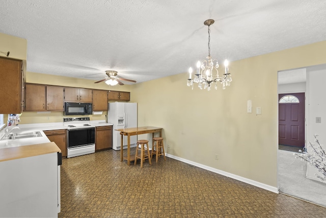 kitchen featuring a textured ceiling, sink, hanging light fixtures, and white appliances