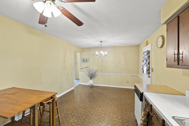 dining space with ceiling fan with notable chandelier and a textured ceiling