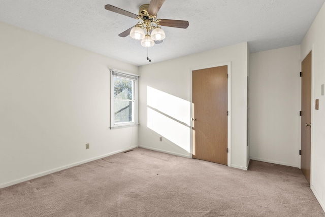 carpeted spare room with ceiling fan and a textured ceiling