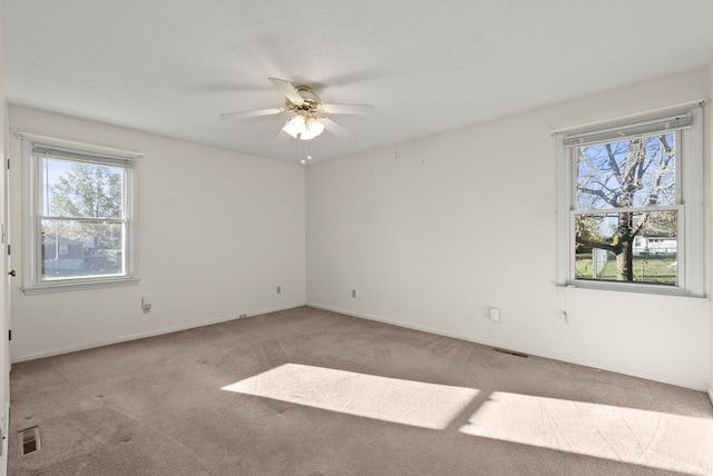 carpeted spare room with ceiling fan