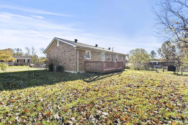 back of property featuring a yard, cooling unit, and a wooden deck