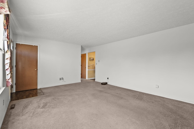 carpeted spare room featuring a textured ceiling