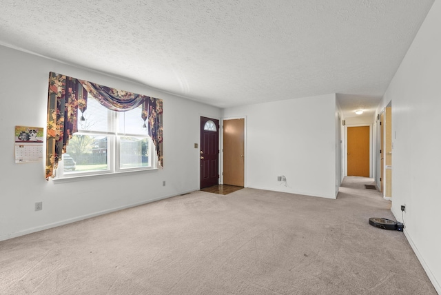 spare room with a textured ceiling and light carpet