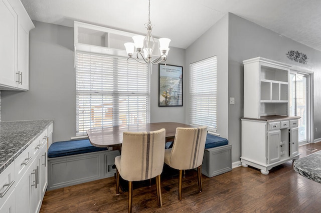 dining space featuring dark hardwood / wood-style floors, an inviting chandelier, and vaulted ceiling