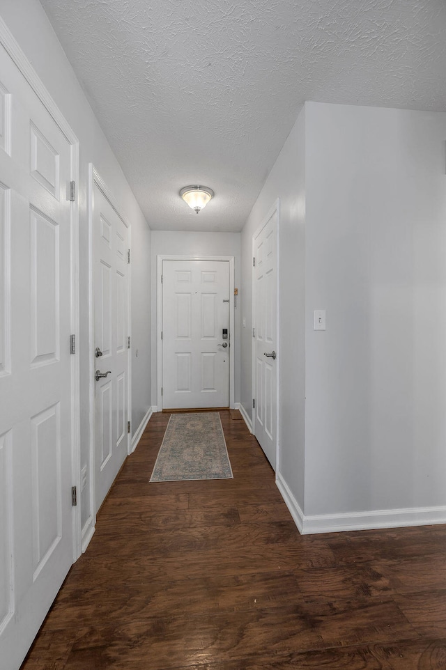 entryway with dark hardwood / wood-style flooring and a textured ceiling