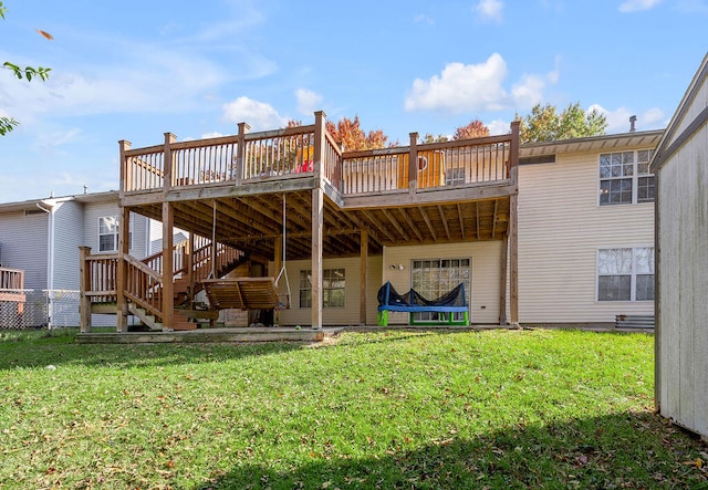 back of property featuring a deck and a lawn