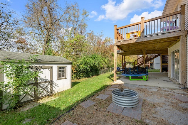 view of yard featuring a wooden deck, an outdoor fire pit, and a patio area