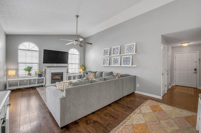 living room with ceiling fan, dark hardwood / wood-style floors, and vaulted ceiling