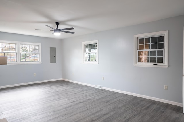 unfurnished room with electric panel, dark hardwood / wood-style floors, and ceiling fan