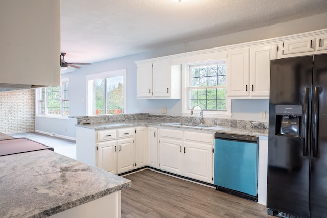 kitchen with black fridge, sink, stainless steel dishwasher, and white cabinets