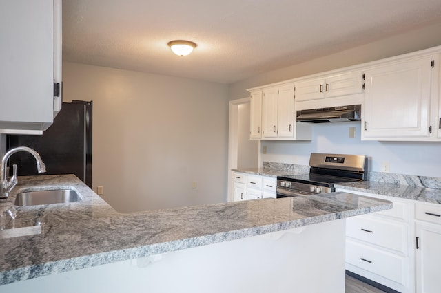 kitchen featuring sink, light stone countertops, a textured ceiling, white cabinets, and stainless steel range