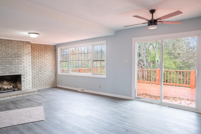 unfurnished living room with a fireplace, a wealth of natural light, ceiling fan, and hardwood / wood-style flooring