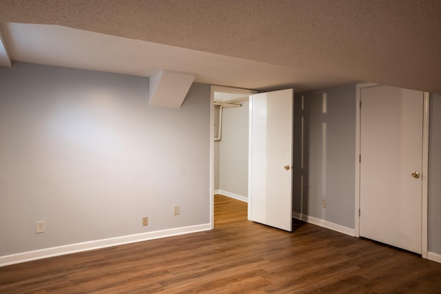 basement featuring a textured ceiling and hardwood / wood-style flooring