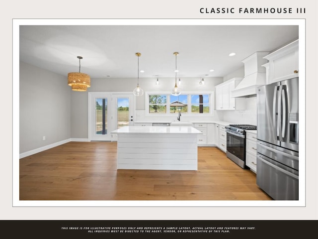 kitchen featuring light hardwood / wood-style floors, white cabinetry, appliances with stainless steel finishes, decorative light fixtures, and a kitchen island