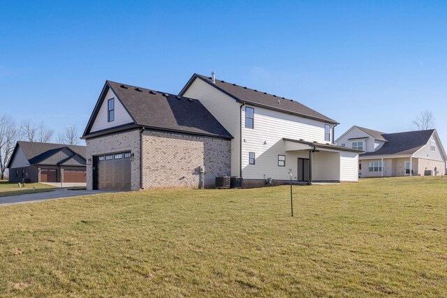 view of side of property featuring a yard, cooling unit, driveway, brick siding, and a garage