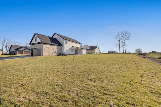 view of yard with driveway and a garage