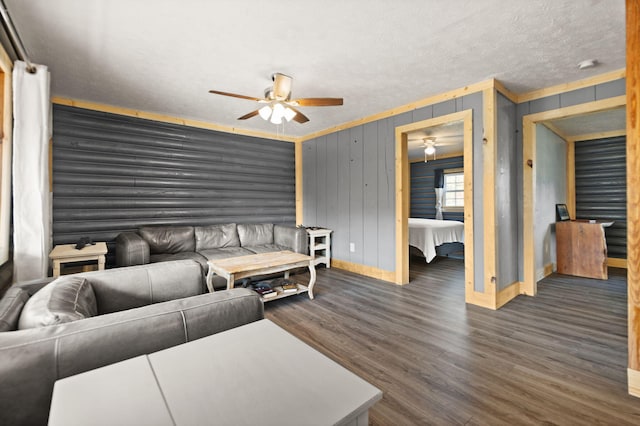 living room with a textured ceiling, crown molding, and dark hardwood / wood-style floors