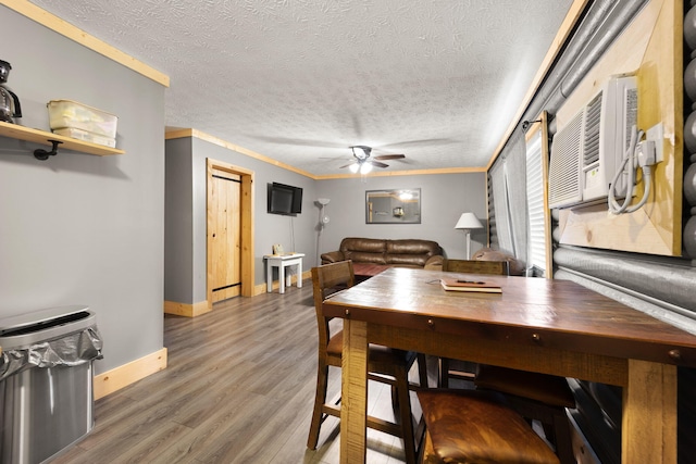 dining room featuring ceiling fan, a textured ceiling, hardwood / wood-style flooring, and crown molding