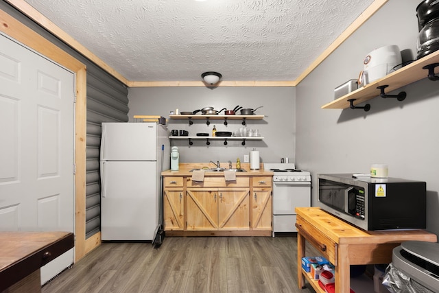 kitchen featuring white appliances, a textured ceiling, wood-type flooring, sink, and ornamental molding