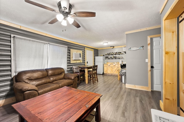 living room featuring hardwood / wood-style flooring, a textured ceiling, ornamental molding, and ceiling fan