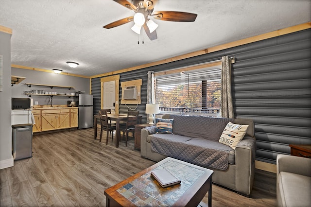 living room with hardwood / wood-style flooring, sink, a textured ceiling, and ceiling fan