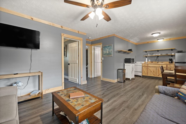 living room featuring ceiling fan, dark hardwood / wood-style floors, a textured ceiling, crown molding, and sink