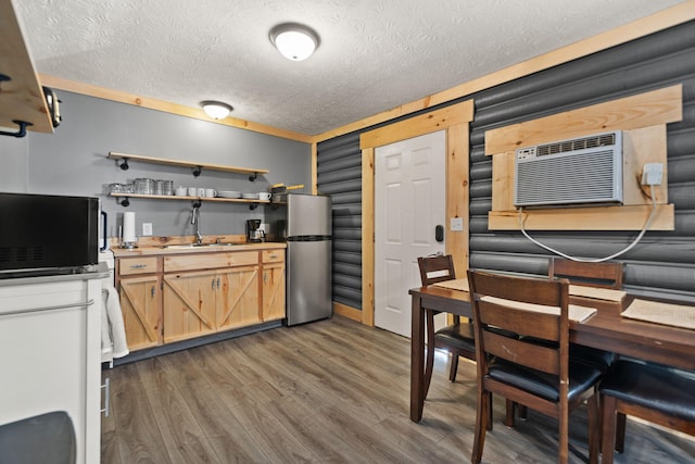 kitchen with sink, stainless steel refrigerator, a textured ceiling, and hardwood / wood-style floors