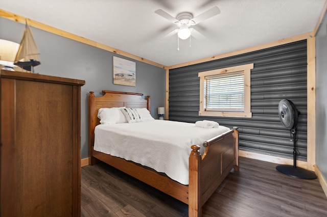 bedroom with ceiling fan, dark hardwood / wood-style floors, and log walls