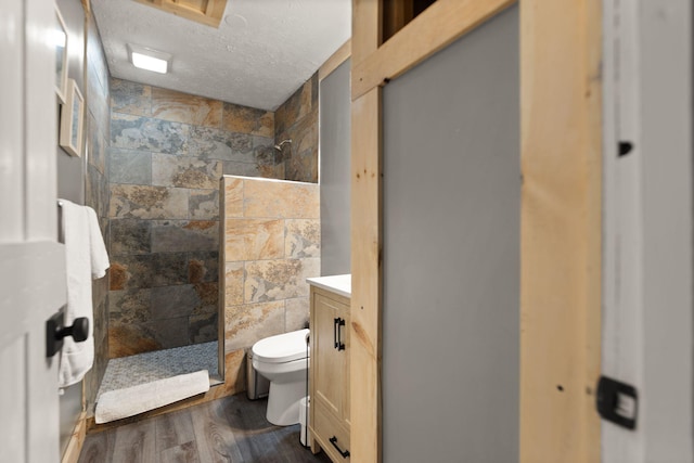 bathroom with vanity, a shower, a textured ceiling, and hardwood / wood-style flooring